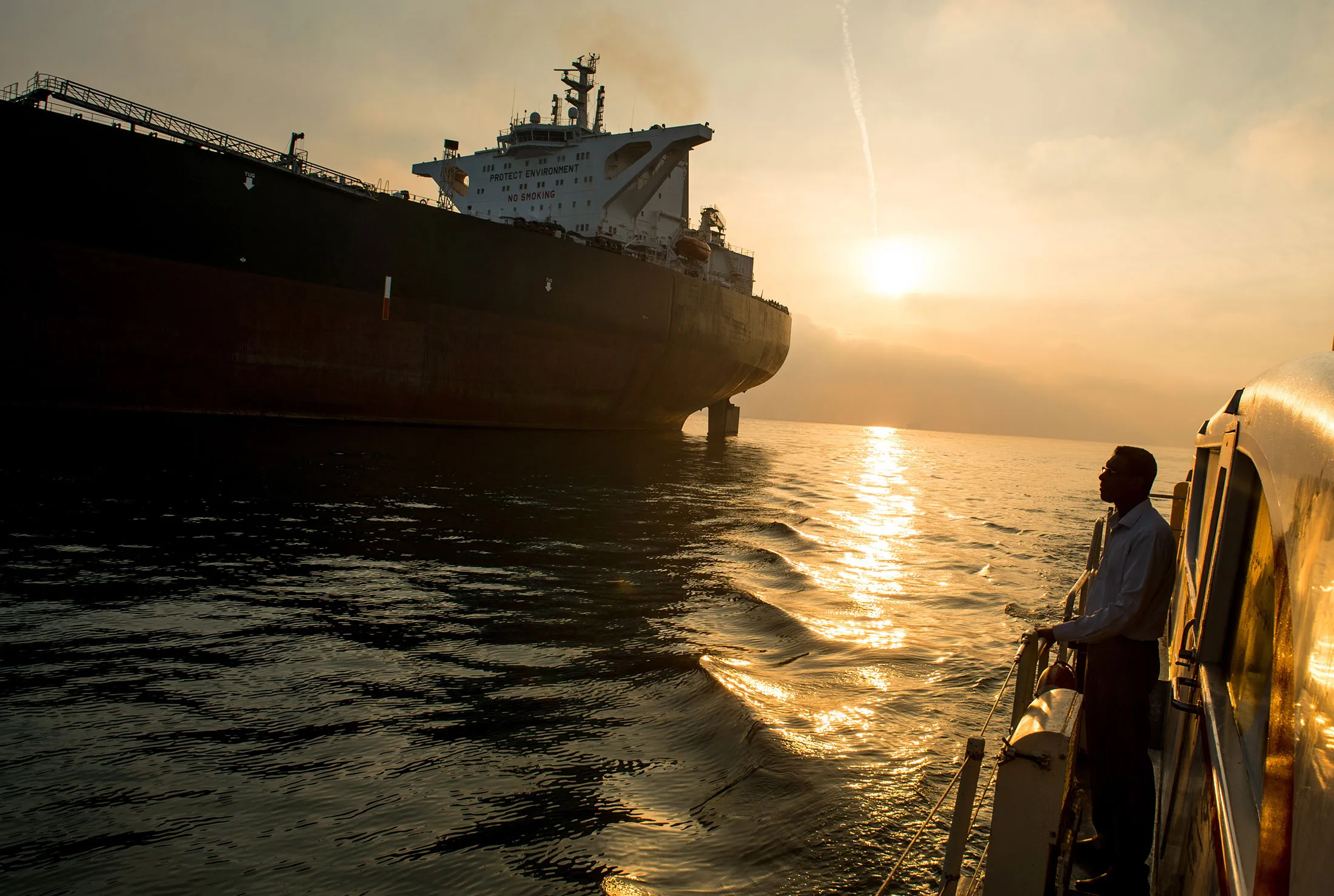 A support vessel flying an Iranian national flag sails alongside the oil tanker 'Devon' as it prepares to transport crude oil to export markets in Bandar Abbas, Iran, on Friday, March 23, 2018.