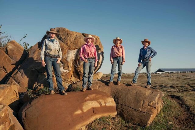The Penfold daughters, Jemima, Matilda, Molly and Bonnie all pose on top of rocks covered in red dirt. 