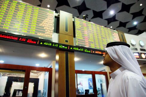 An investor monitors electronic stock boards at the Dubai Financial Market.