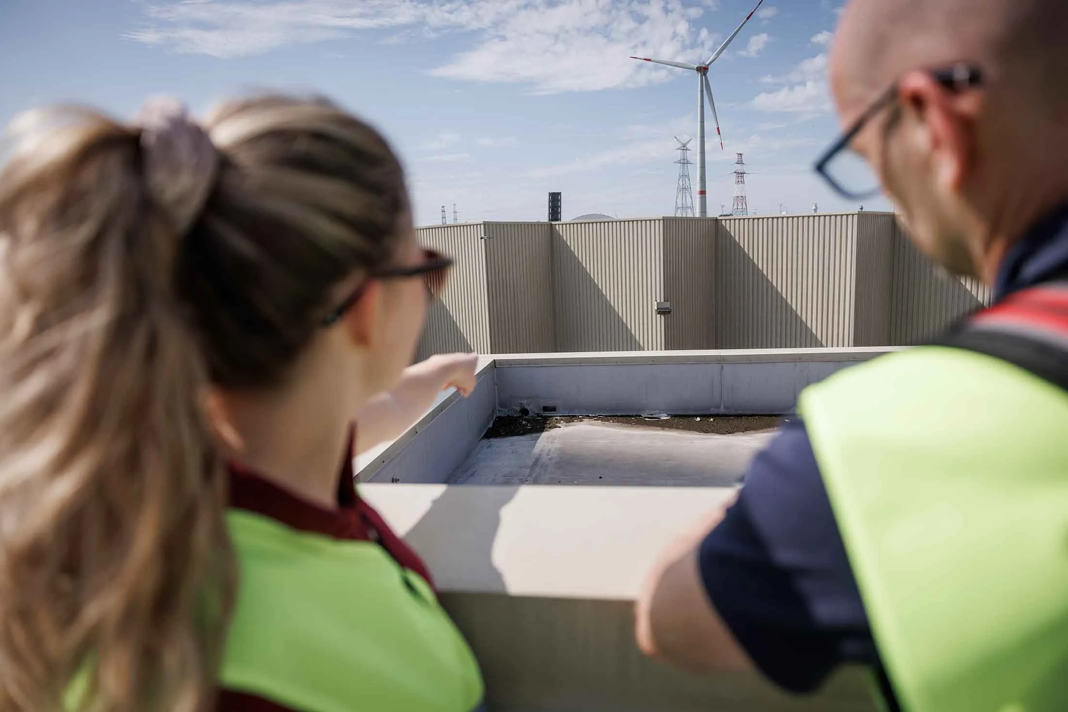 Tabea van Hasselt, a climate risk engineer at ZRS, points to dirt and pooled water on a roof during a risk evaluation of Katoen Natie's facilities in Antwerp, Belgium.