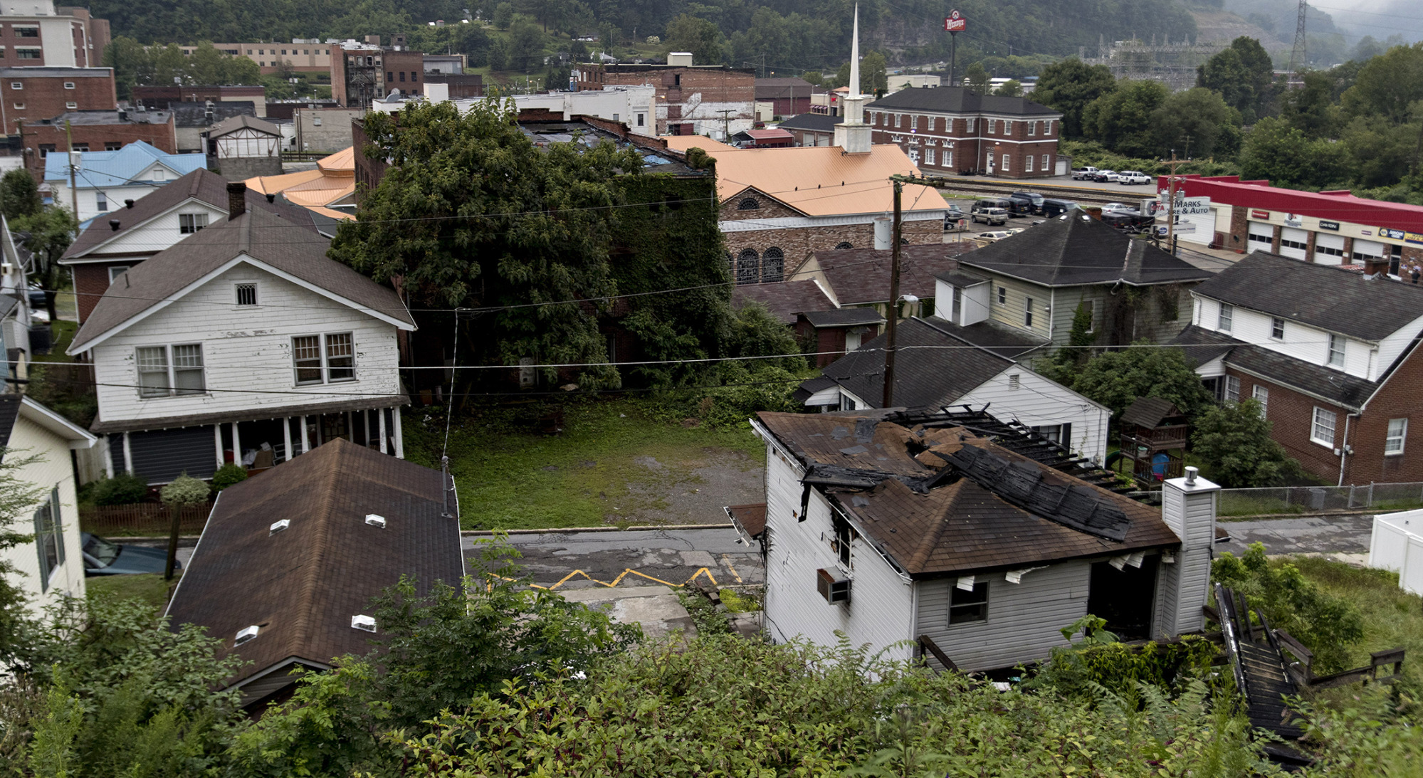 An abandoned house, right, stands in Logan, West Virginia.