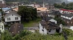 An abandoned house, right, stands in Logan, West Virginia.