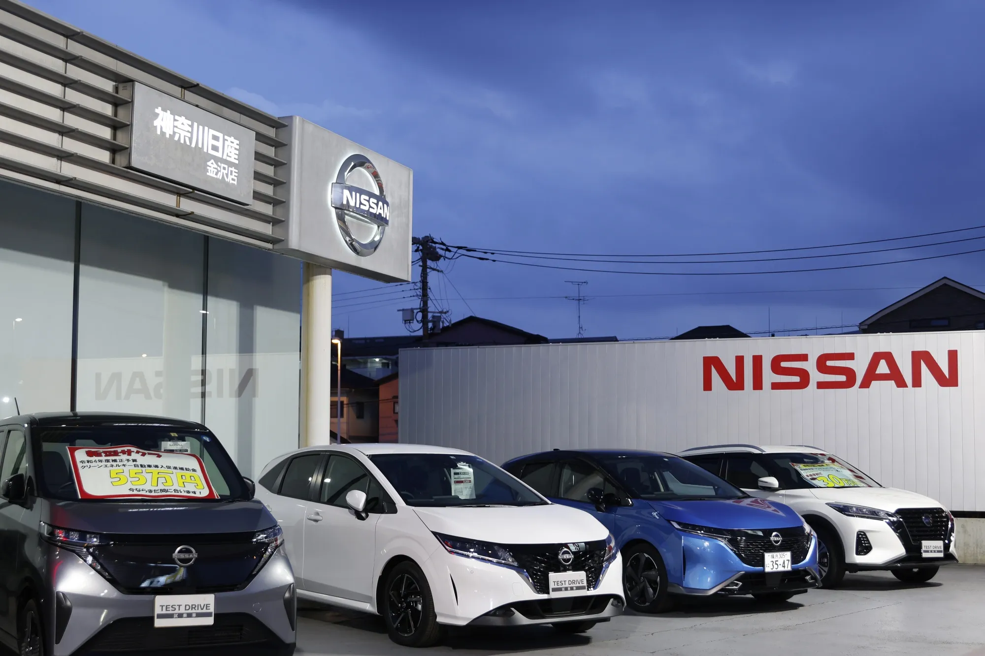 Nissan Motor Co. vehicles at a Nissan dealership at dusk in Yokohama, Japan.