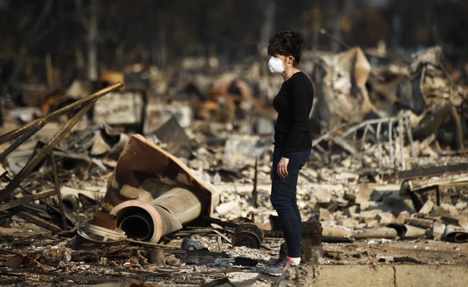 A resident stands in what remains of her home, which was destroyed by a wildfire in the Coffey Park neighborhood in Santa Rosa, California.