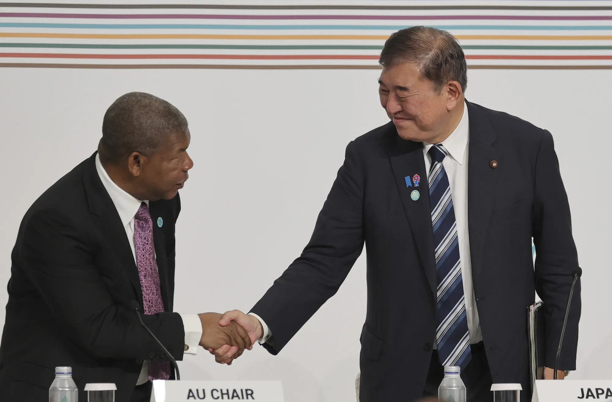 Shigeru Ishiba, right, shakes hands with Angolan President Joao Lourenco in Yokohama.