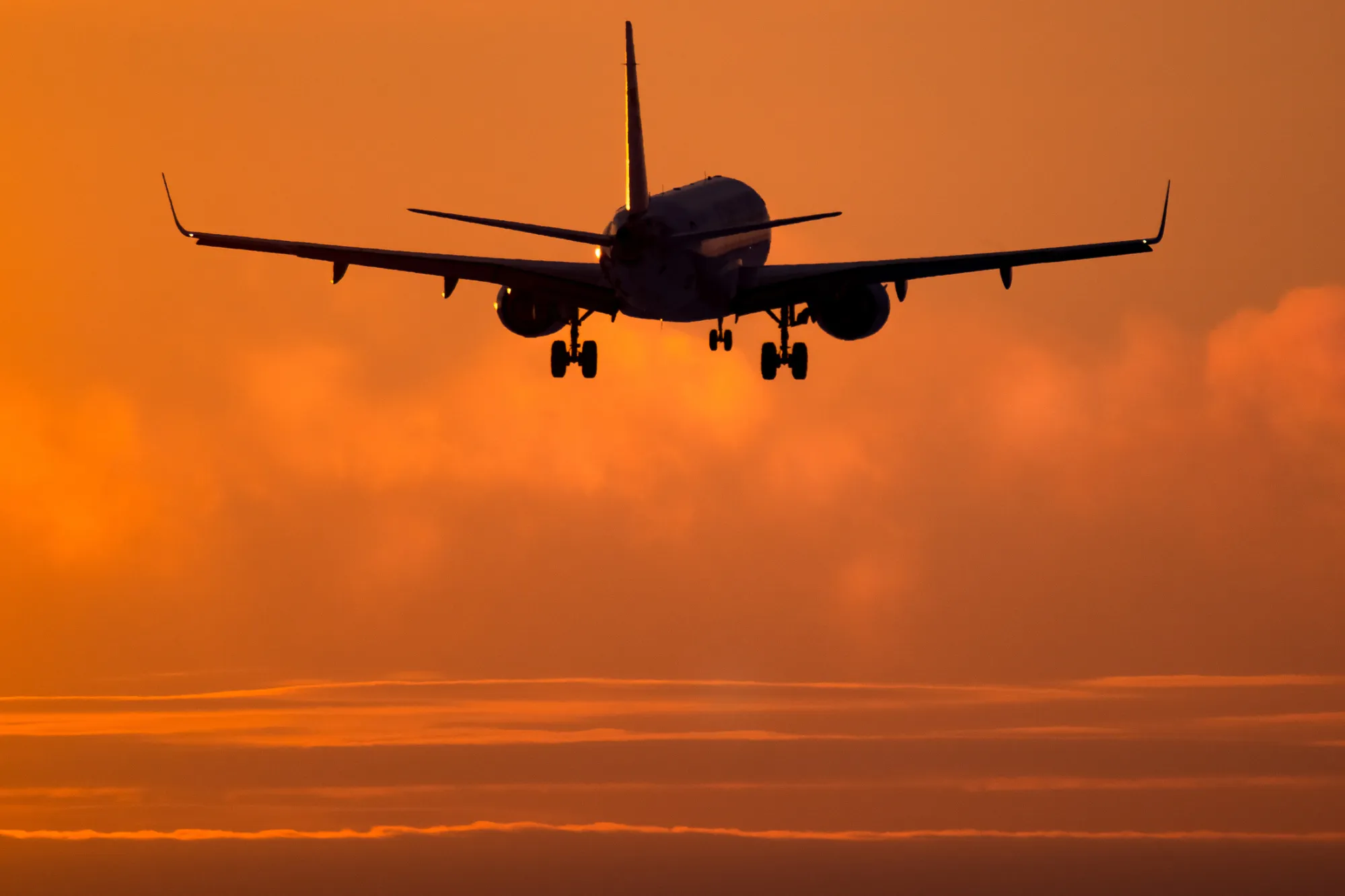 Airplane landing at sunset