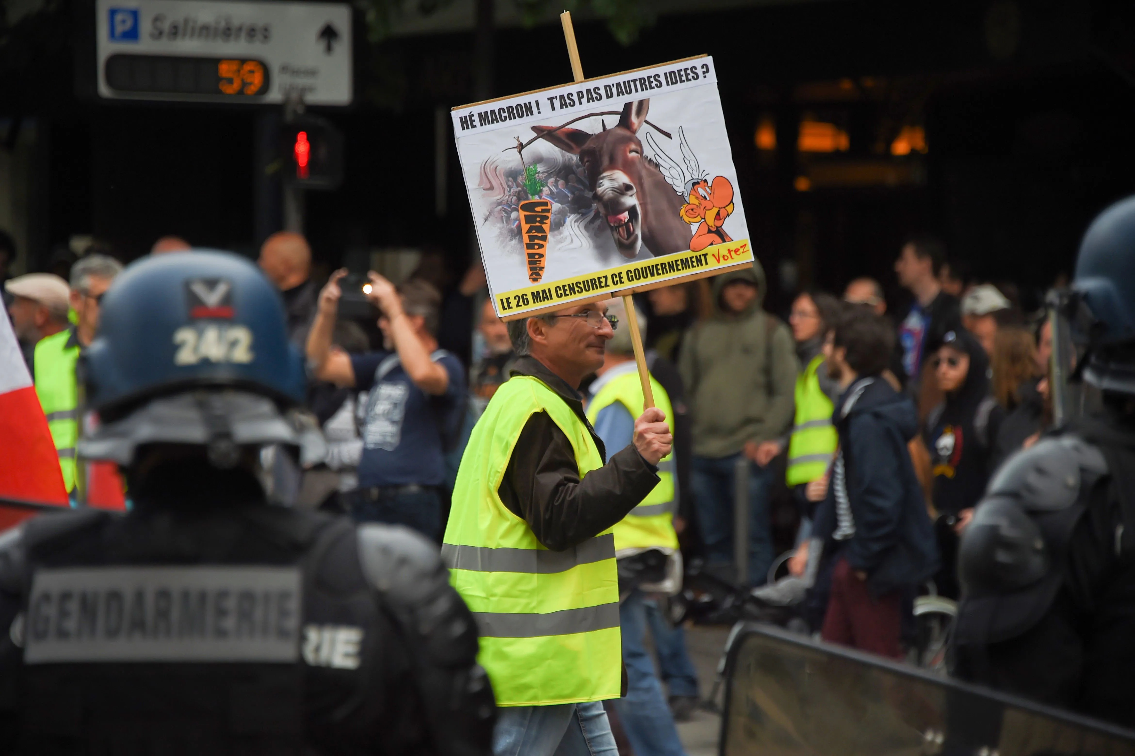 A protester holds a placard reading in French "Hey Macron! Don't you have any other ideas ?" on a street in&nbsp;Bordeaux.