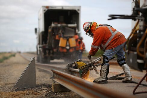 A maintenance-of-way worker saws through a piece of rail, in Alva, Okla., on Aug. 19.