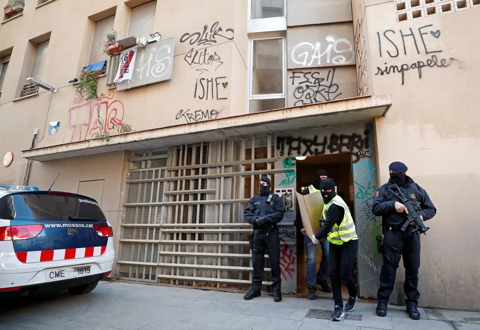 Police officers of Mossos d'Esquadra carry evidence during an anti-terrorist operation in Barcelona, where crime has been on the rise.