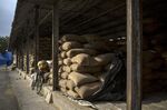 Sacks of paddy rice stacked at a wholesale grain market in Uttar Pradesh, India.