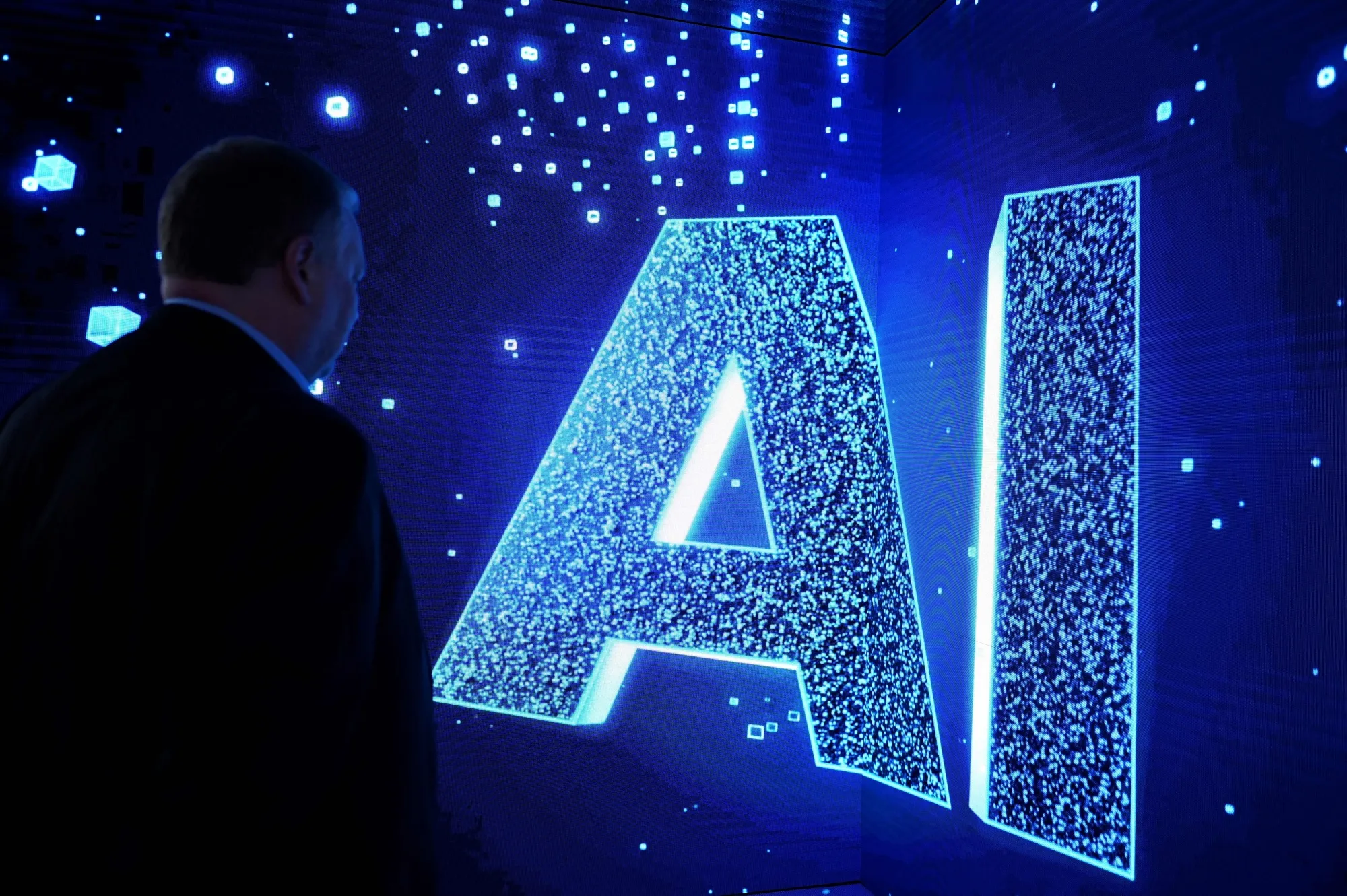 A visitor watches an AI (Artificial Intelligence) sign on an animated screen at the Mobile World Congress, the telecom industry's biggest annual gathering, in Barcelona.&nbsp;