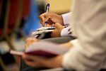 A job seeker takes notes during employer presentations at a United Career Fairs sales and management hiring event in Oak Brook, Illinois, U.S., on Tuesday, July 17, 2018.