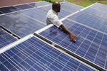 An employee inspects solar panels in the village of Dharnai in India.

