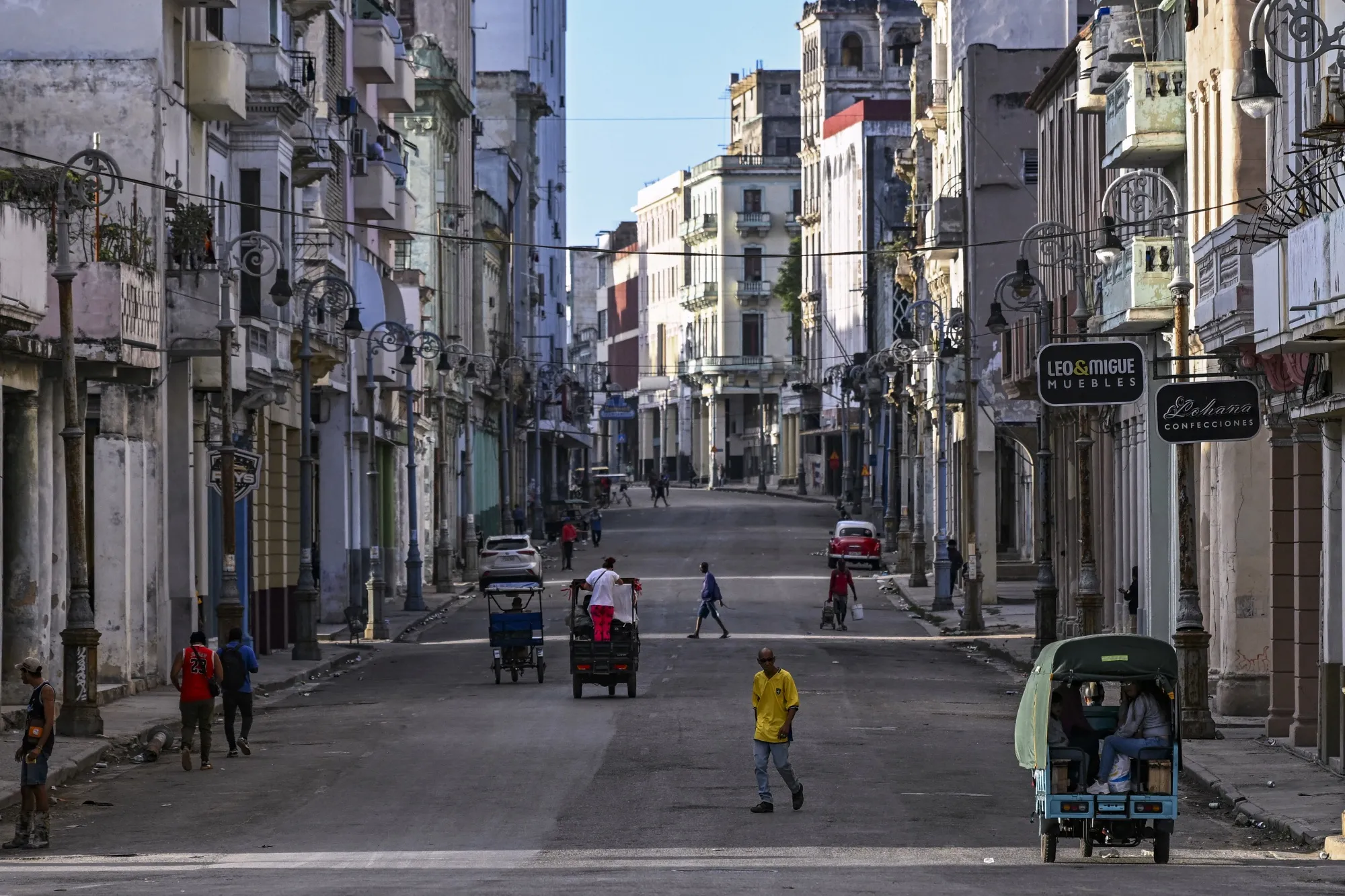People walk and ride on a street without power in Havana, during a nationwide blackout in March.