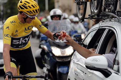 Great Britain's Christopher Froome wearing the overall leader's yellow jersey toats with champagne as he takes the start of the 103 km twenty-first and last stage of the 104th edition of the Tour de France cycling race on July 23, 2017 between Montgeron and Paris Champs-Elysees. / AFP PHOTO / POOL / BENOIT TESSIER (Photo credit should read BENOIT TESSIER/AFP/Getty Images)