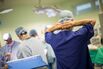 A member of medical staff secures his face mask inside a operating theater