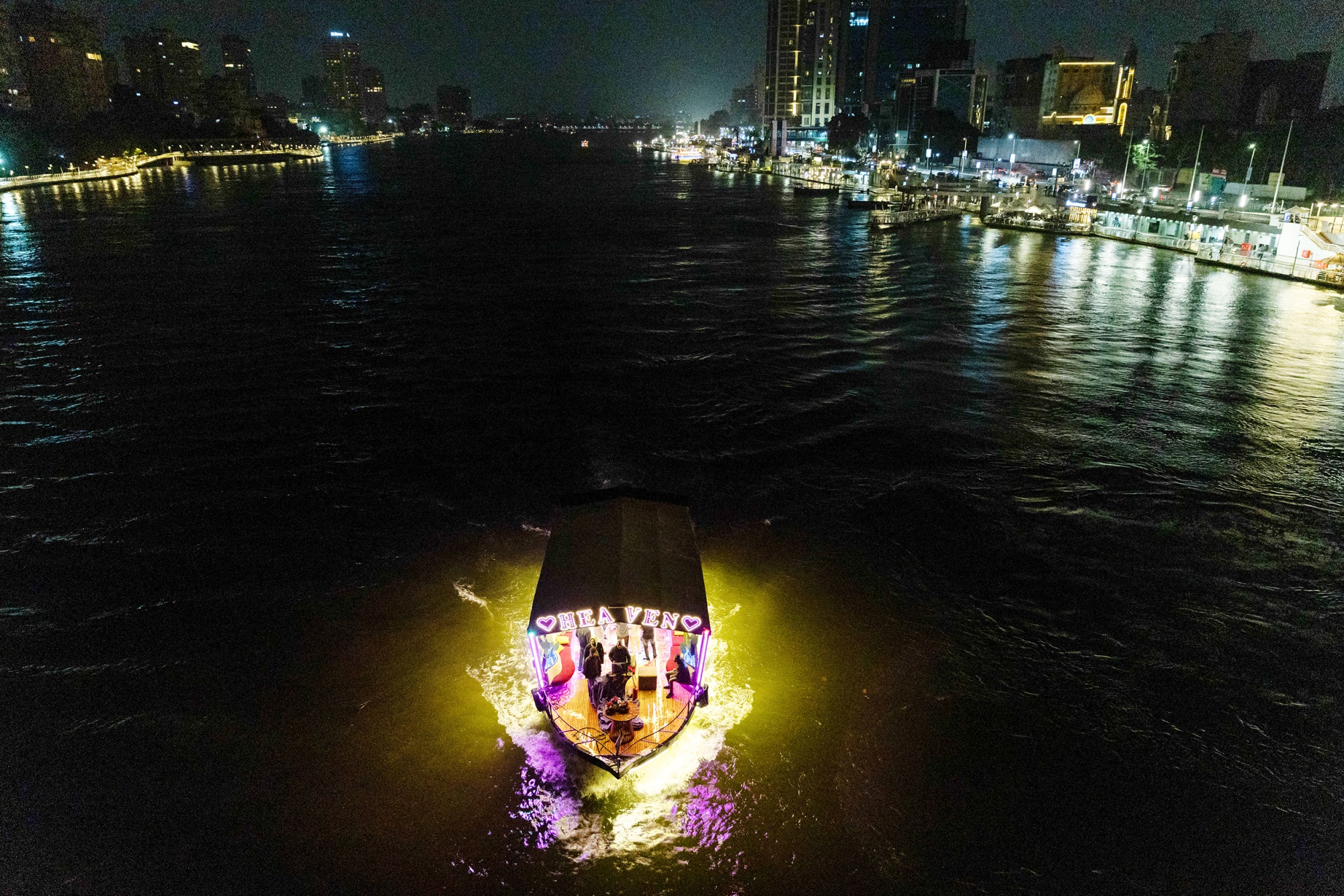 An illuminated river cruise boat on the River Nile near the Mamsha Ahl Misr walkway along by the River Nile Corniche in Cairo, Egypt, on Wednesday, April 1, 2026. Egypt will begin curbing some electricity use, including by ordering shops and cafes to close earlier, as the North African energy importer grapples with soaring global fuel costs caused by the Iran war. Photographer: Islam Safwat/Bloomberg