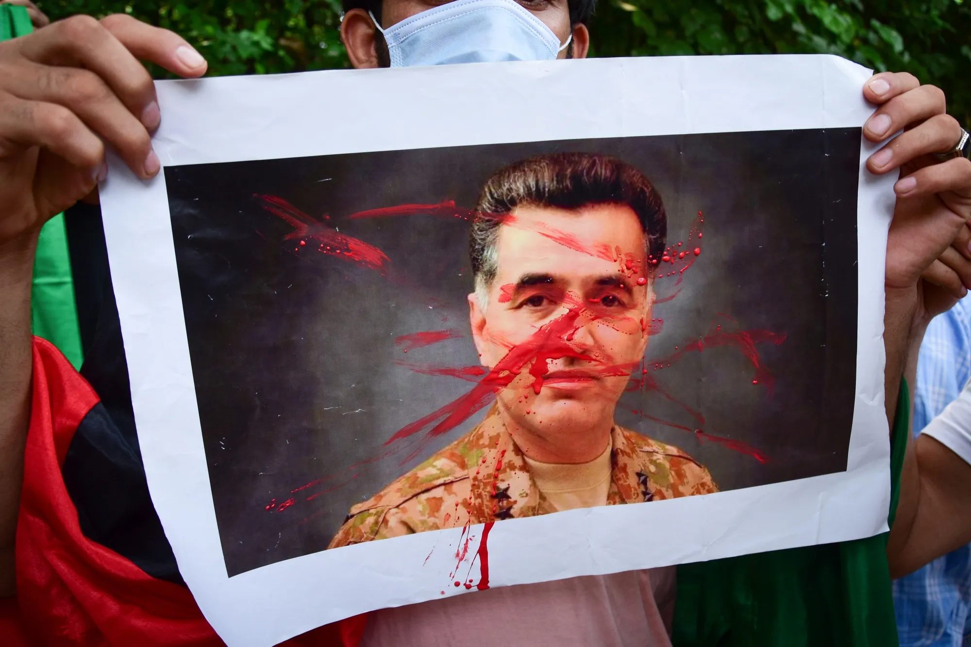 A protester with an image&nbsp;of Pakistan's Lieutenant General Faiz Hameed during a demonstration, in New Delhi, in 2021.
