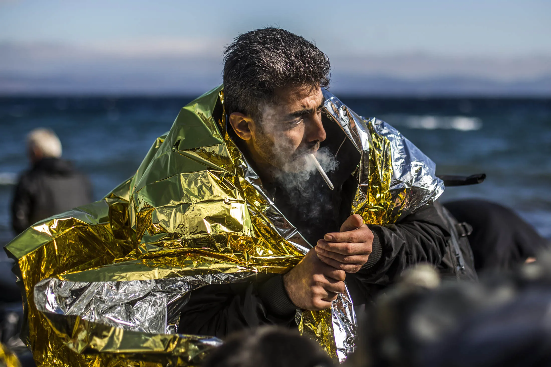 A man smokes cigarette as he arrives with other refugees on the shores of the Greek island of Lesbos. The country expects at least 800,000 refugees to enter its borders this year, the biggest movement of displaced people Europe has seen since World War II.
