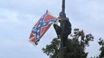 Bree Newsome of Charlotte, N.C., removes the Confederate battle flag at a Confederate monument at the Statehouse in Columbia, S.C., on Saturday, June, 27, 2015. She was taken into custody when she came down. The flag was raised again by capitol workers about 45 minutes later.