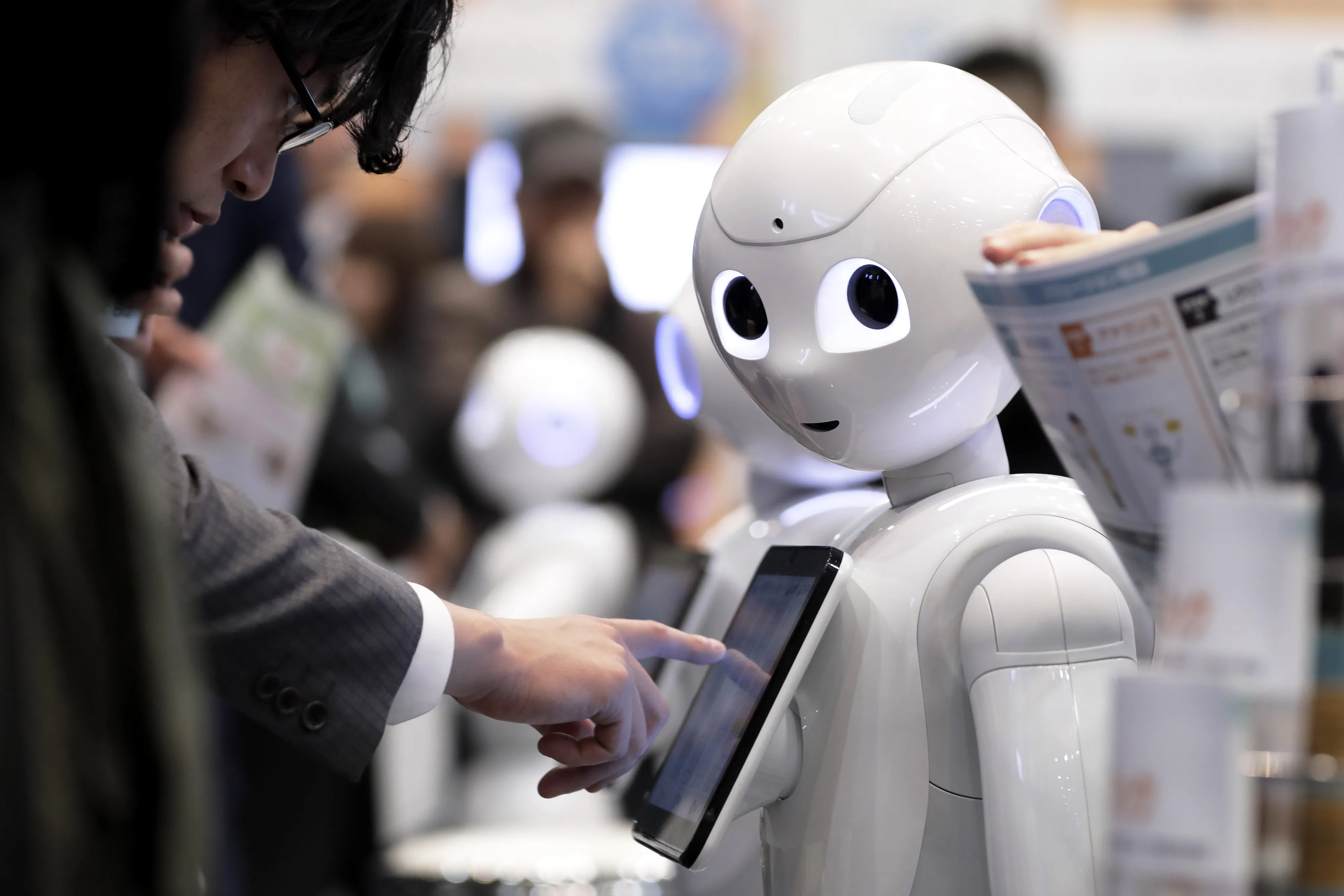 An attendee tries out an application on a SoftBank Group Corp. Pepper humanoid robot at the SoftBank Robot World 2017 in Tokyo, Japan.