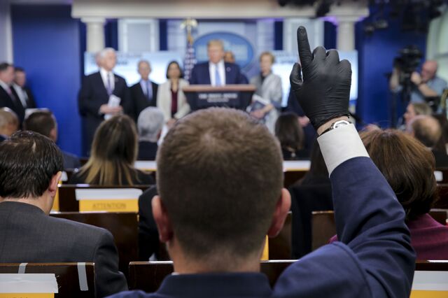 A member of the media wears protective gloves during a news conference at the White House in Washington, D.C.