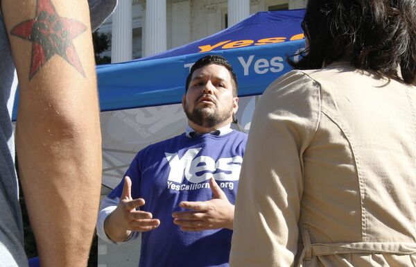 Marcus Ruiz Evans, center, of The Yes California Independence Campaign, talks to passersby about California succeeding from the United States and becoming its own nation, Wednesday, Nov. 9, 2016, in Sacramento, Calif., . Support for the proposal grew on social media following Tuesday's election of Republican Donald Trump.(AP Photo/Rich Pedroncelli)