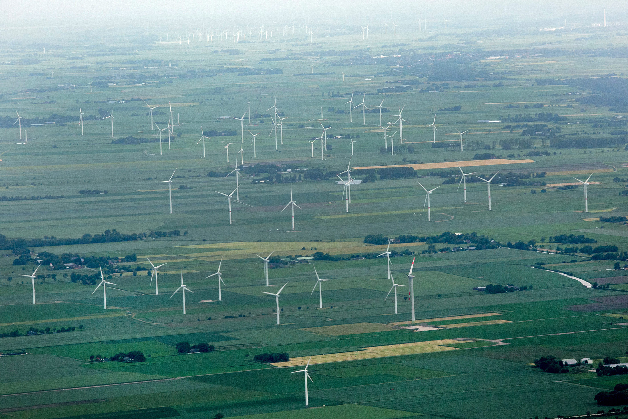 Wind turbines operate on onshore farm land sites in this aerial photograph taken near Hamburg.
