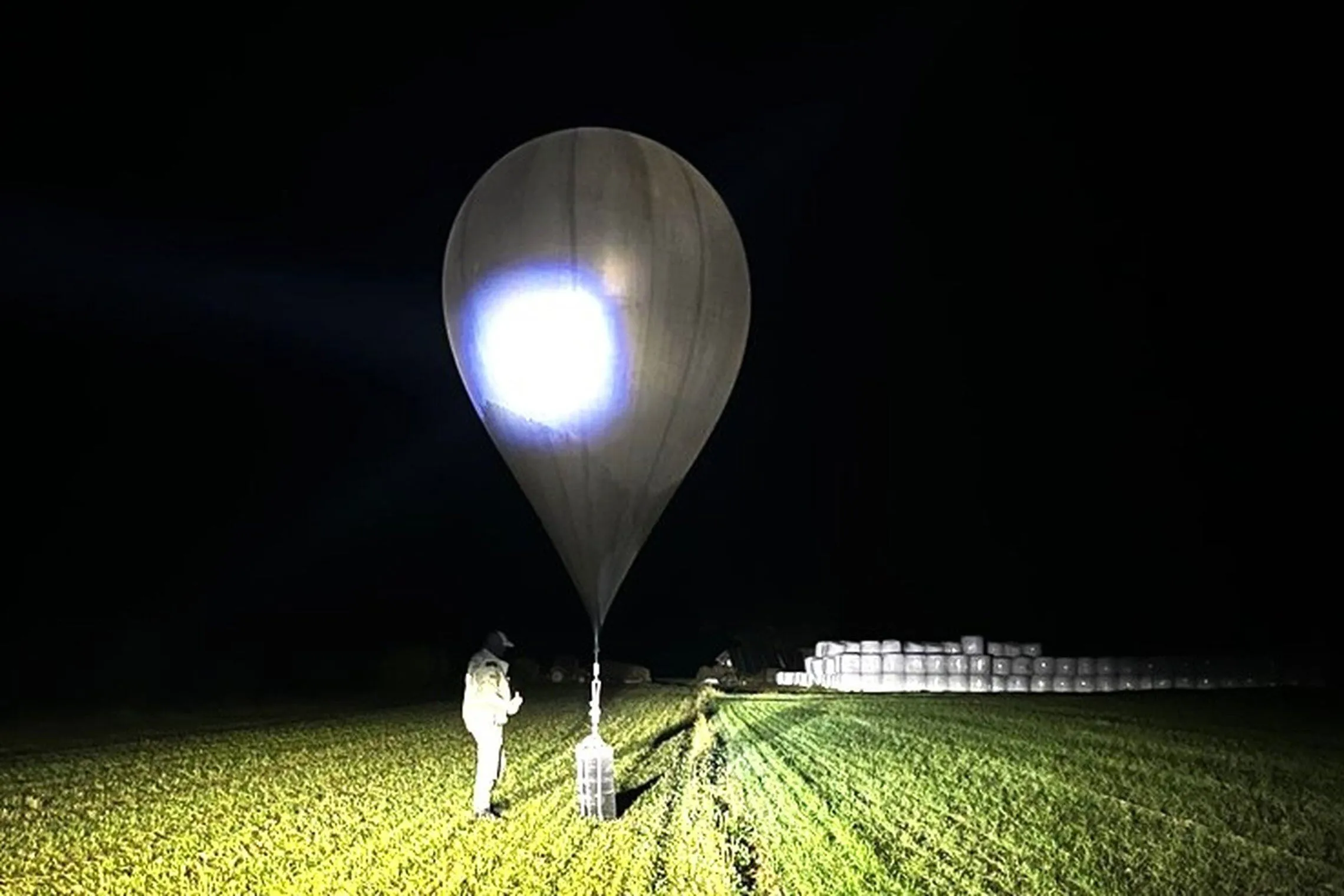 In an undated photo released by Lithuania's State Border Guard Service, an official inspects a balloon used to carry cigarettes.