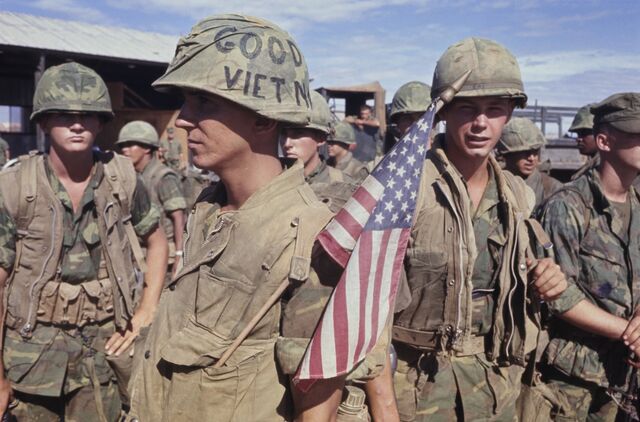 US Marines 1st Battalion soldies, 9th Squadron, in Quang Tri, South Vietnam, July 14, 1969: Soldiers are in camouflage. One soldier is holding a small American flag.