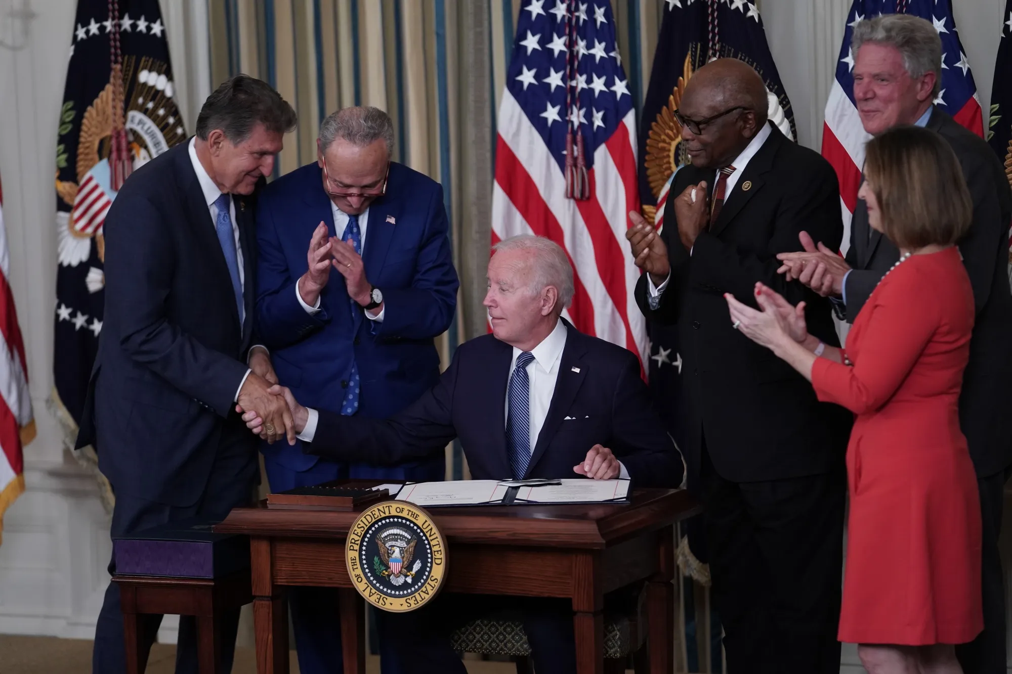 US President Joe Biden shakes hands with Senator Joe Manchin of West Virginia, who has been until recently one of the biggest obstacles to his domestic agenda, after signing the Inflation Reduction Act of 2022 at the White House.