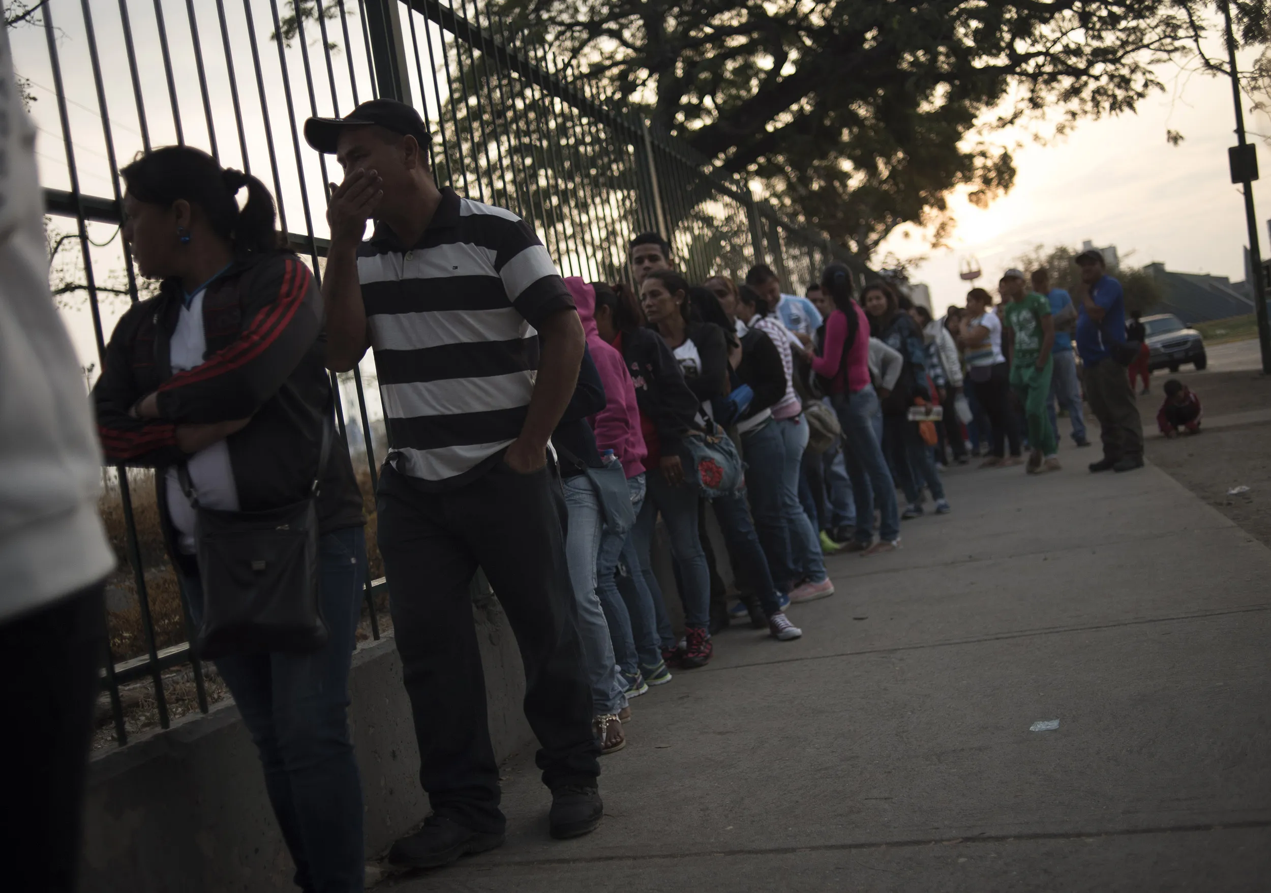 People wait in line outside a supermarket in Barquisimeto.
