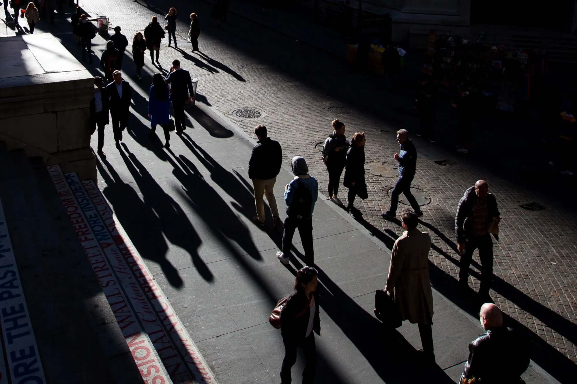 Pedestrians walk along Wall Street near the New York Stock Exchange.