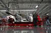 Tesla Motor Inc. associates work on the Model S electric car at the company's factory in Fremont, California, U.S., on Wednesday, April 11, 2012. Tesla aims for the the second-hand plant, equipped with refurbished machinery and Ikea furniture, to be able produce plug-in cars to take on the likes of BMW's 5 Series in just a few months and to do so profitably.
