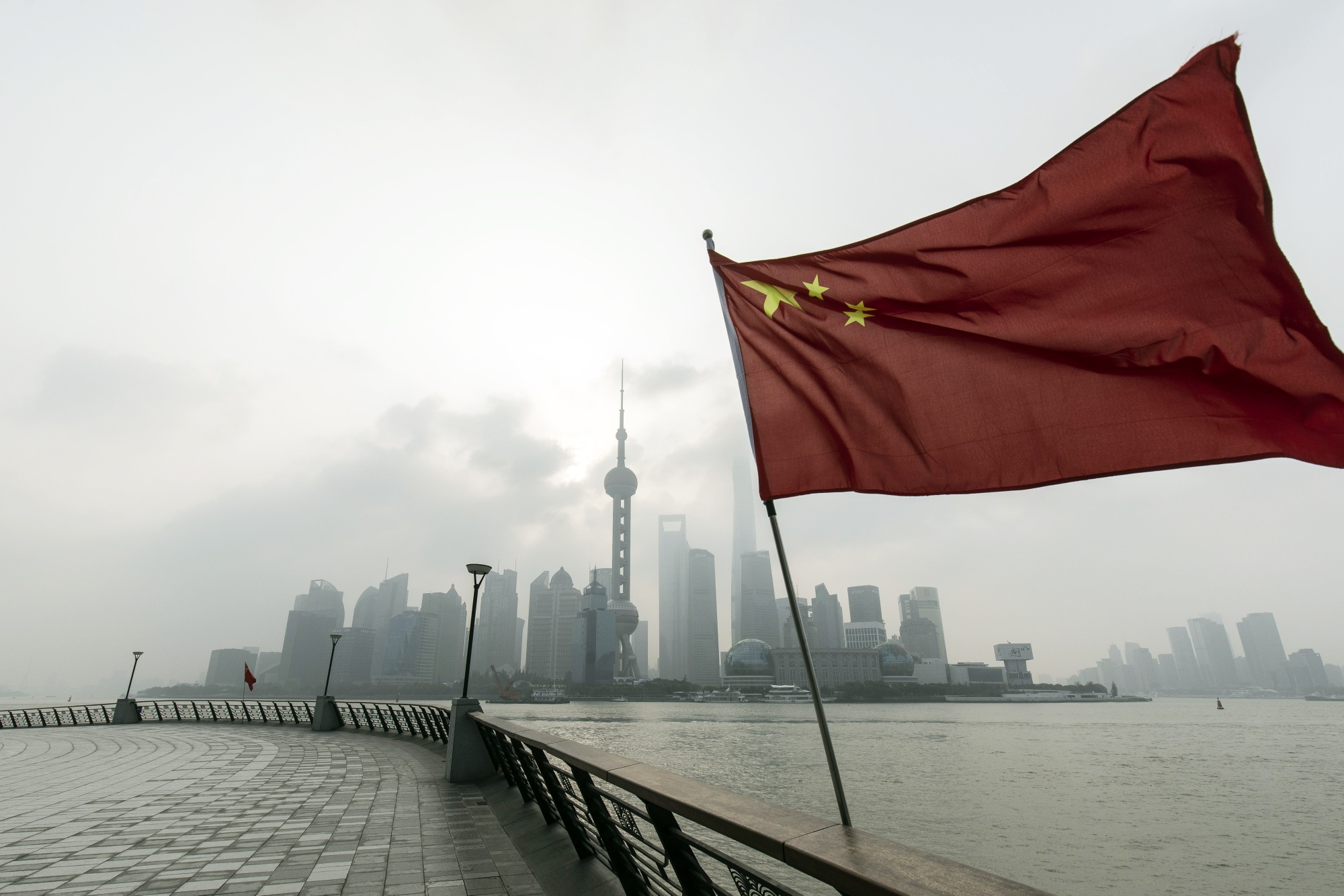 A Chinese flag in front of buildings in Pudong's Lujiazui Financial District in Shanghai.