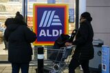 Shoppers wait outside Aldi supermarket. According to a