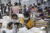 Employees use sewing machines on a production line at a factory in Tiruppur, Tamil Nadu.