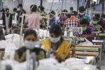 Employees use sewing machines on a production line at a factory in Tiruppur, Tamil Nadu.