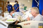 Rishi Sunak speaks with patient Catherine Poole during a visit to Croydon University Hospital, in London on Oct. 28.