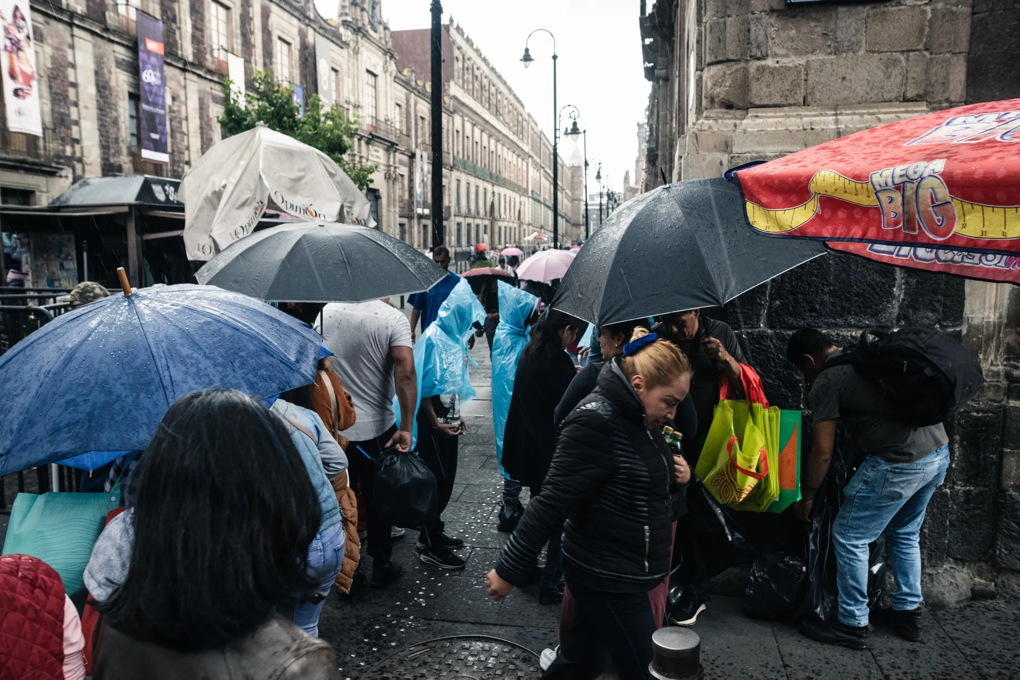 Peatones se protegen de la lluvia bajo sus paraguas en la Ciudad de México.