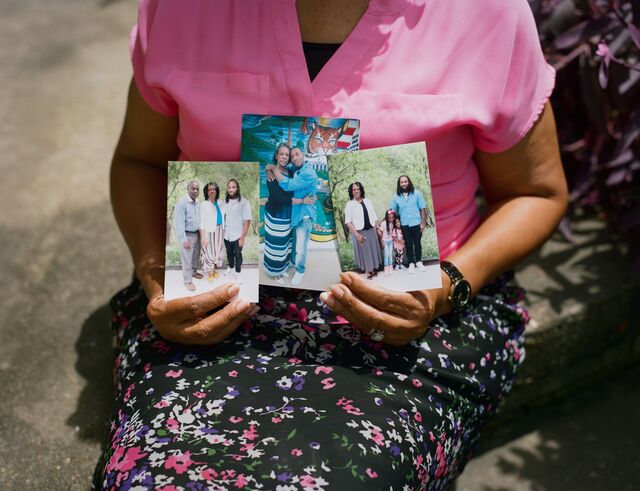 Amos holding photos of her family.