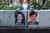 A demonstrator stands above posters featuring Hong Kong Chief Executive Carrie Lam, right, and Hong Kong Secretary for Justice Teresa Cheng in Hong Kong.