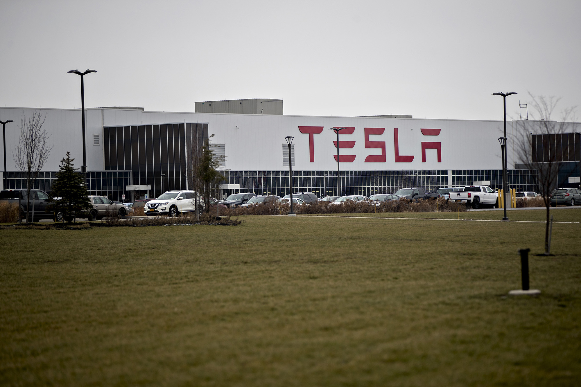 Vehicles sit parked outside the Tesla solar panel factory in Buffalo, New York.