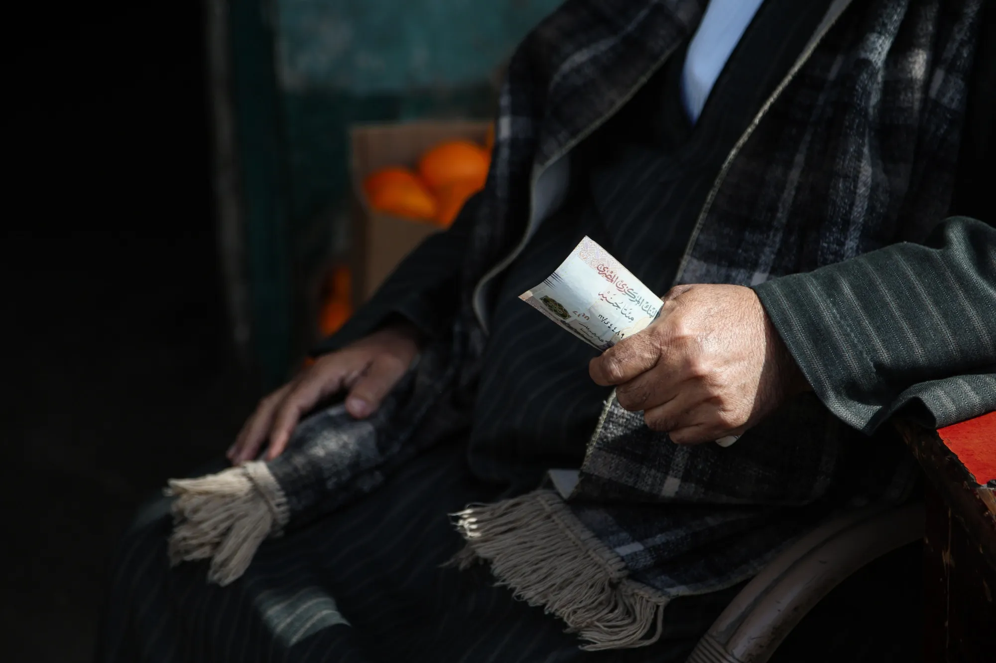 A customer holds Egyptian pound banknotes at the El Obour wholesale market in Cairo.