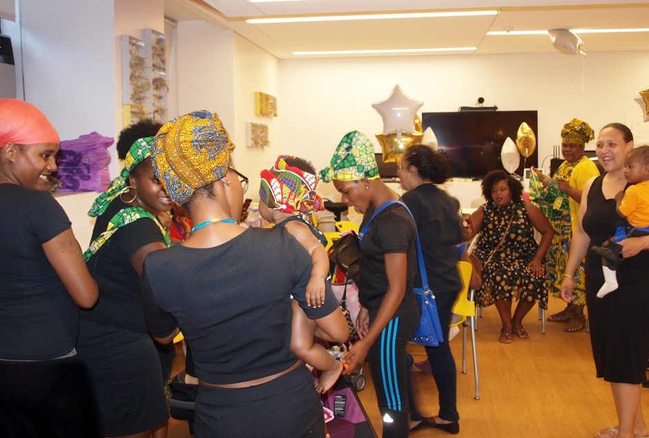 Moms socialize and try on African prints during a celebration of Black Breastfeeding Awareness Week.