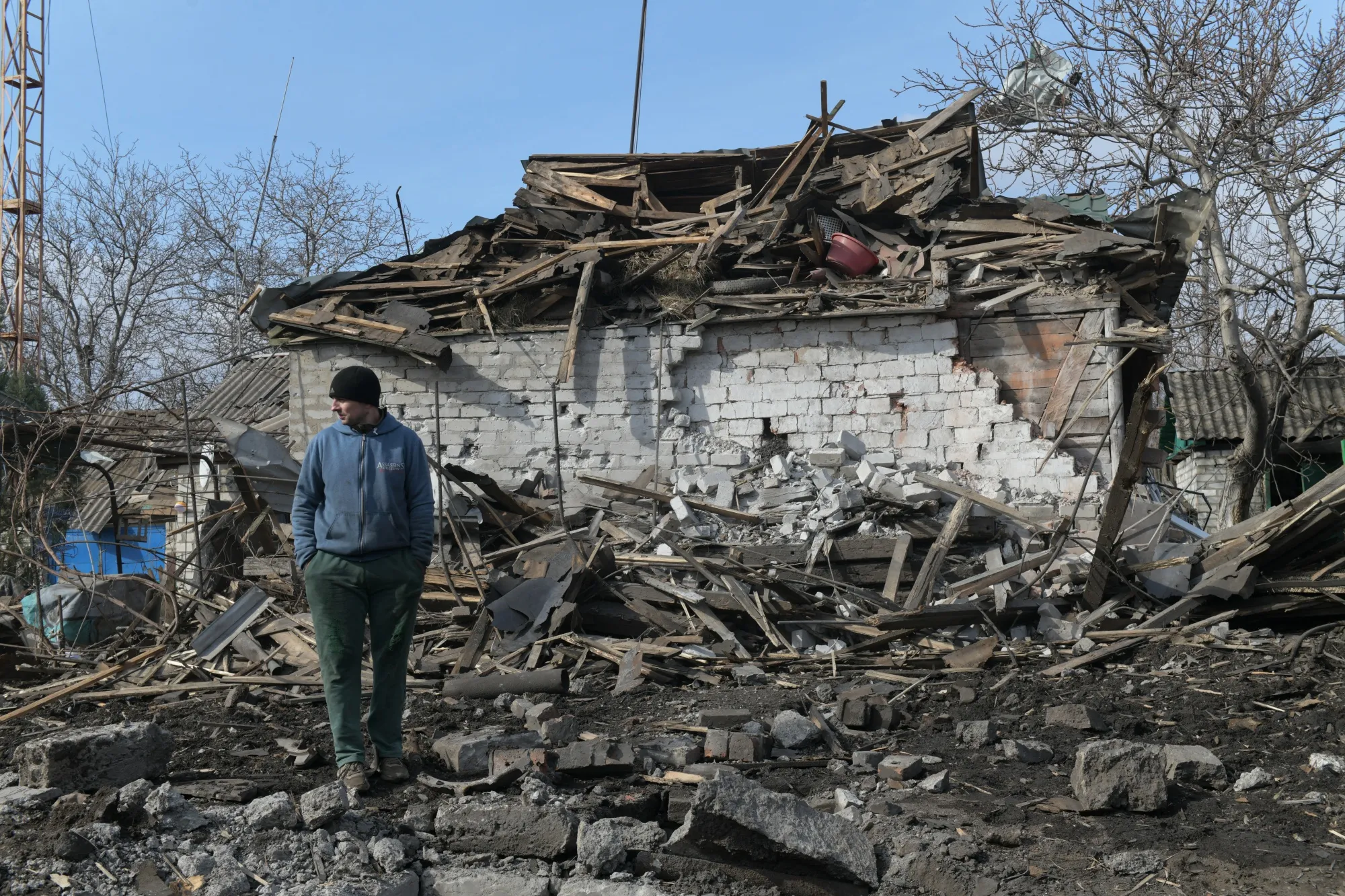 A man stands in the yard of a destroyed house following recent shelling in the Donetsk region of Russian-controlled Ukraine on March 5.
