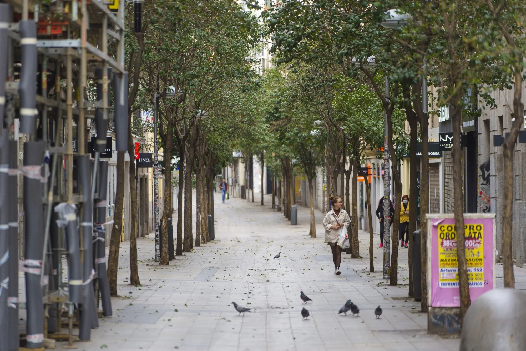 Pedestrians walk down an almost-deserted Fuencarral Street in Madrid.