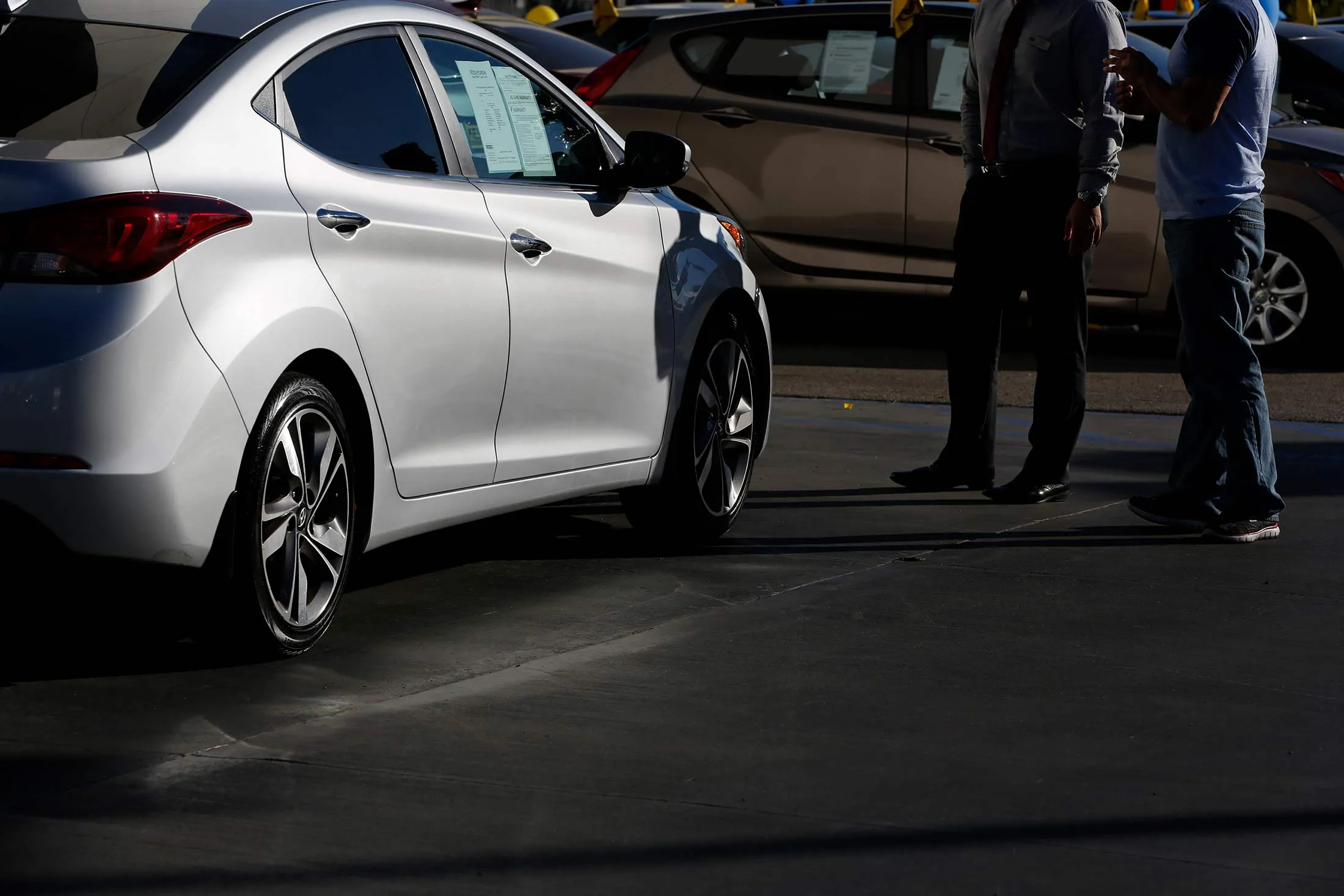 A salesman speaks to a potential car buyer at a dealership in Los Angeles, Calif.
