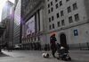 People walk past the New York Stock Exchange (NYSE) at Wall Street.