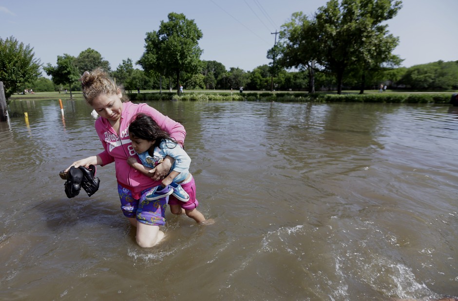 A woman carries a daughter's friend through floodwaters in Houston on May 26.